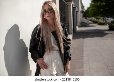 A Beautiful Girl With Long Even Hair Walks Around The City, The Model Is Wearing A Black Braid And White Trousers