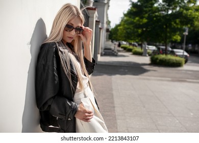 A Beautiful Girl With Long Even Hair Walks Around The City, The Model Is Wearing A Black Braid And White Trousers