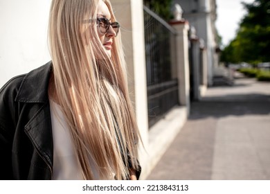 A Beautiful Girl With Long Even Hair Walks Around The City, The Model Is Wearing A Black Braid And White Trousers