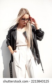 A Beautiful Girl With Long Even Hair Walks Around The City, The Model Is Wearing A Black Braid And White Trousers