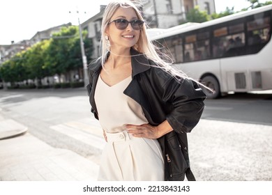 A Beautiful Girl With Long Even Hair Walks Around The City, The Model Is Wearing A Black Braid And White Trousers