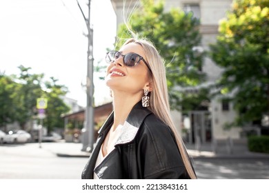 A Beautiful Girl With Long Even Hair Walks Around The City, The Model Is Wearing A Black Braid And White Trousers