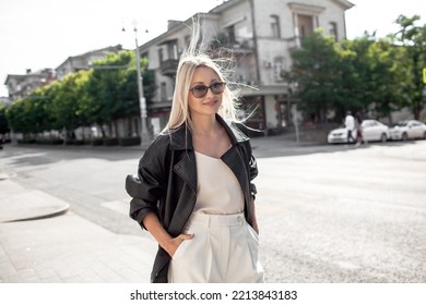 A Beautiful Girl With Long Even Hair Walks Around The City, The Model Is Wearing A Black Braid And White Trousers