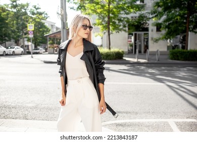 A Beautiful Girl With Long Even Hair Walks Around The City, The Model Is Wearing A Black Braid And White Trousers