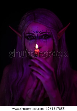 beautiful girl with long hair posing in elf cosplay with colored lights. High quality photo