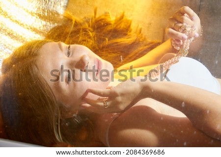 Similar – Woman face lying down over hands with colorful sparkles in skin