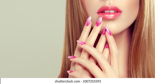 Beautiful girl  long and  straight hair . Model woman showing a pink  manicure french on nails and lips  .