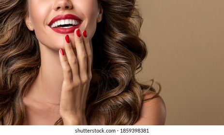 Beautiful girl  long , thick curly hair . Model showing a red manicure on nails and lips  .