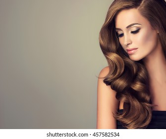 Beautiful girl with long wavy  and shiny  hair . Brunette woman  with curly hairstyle  - Powered by Shutterstock