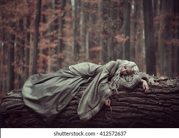 Beautiful girl with long white hair resting in the forest.