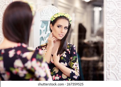 Beautiful Girl Looking In The Mirror And Trying On Floral Dress - Portrait Of A Young Woman In A Dressing Room With A Flower Pattern Dress