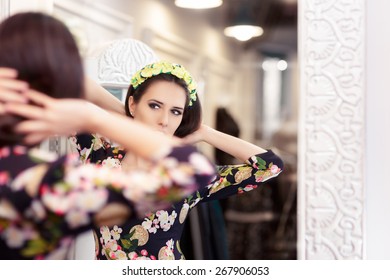 Beautiful Girl Looking In The Mirror And Trying On Floral Dress - Portrait Of A Young Woman In A Dressing Room With A Flower Pattern Dress
