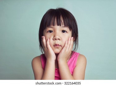 Beautiful Girl Looking Sad With Pouted Lips. Closeup Portrait Of Cute Asian Kid .