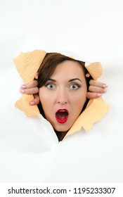 Beautiful Girl Looking Through A Hole In The Paper. Huge Discount For Sale. Astonished Look. Woman Climbs Out Of The Wall.