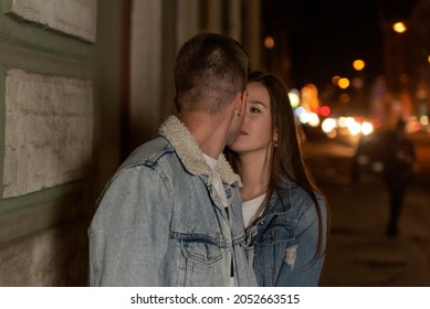 Beautiful Girl Looks Lovingly At Her Boyfriend. Young Couple On An Evening Romantic Date. Night City On The Background.