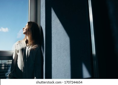 Beautiful girl looks out the window and stands next to him - Powered by Shutterstock