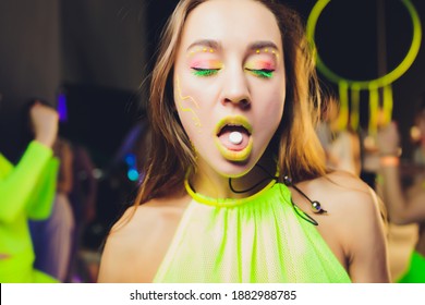 beautiful girl with lsd on tongue in nightclub with pink smoke.