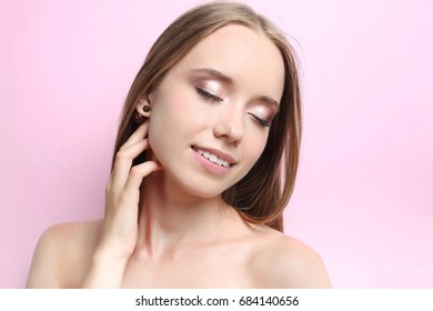Beautiful girl with makeup on a pink background. - Shutterstock ID 684140656