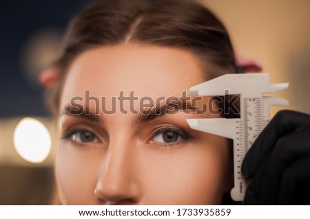 Beautiful girl master eyebrow posing in a beauty salon with laminated eyebrows and natural make-up.