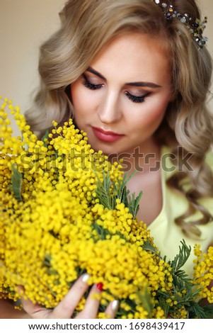 beautiful girl with a Mimosa in a yellow dress