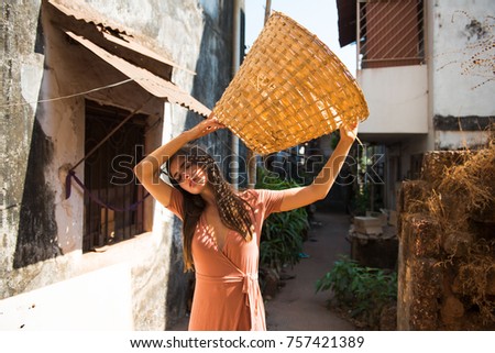 beautiful girl model, in a dress holding a straw basket