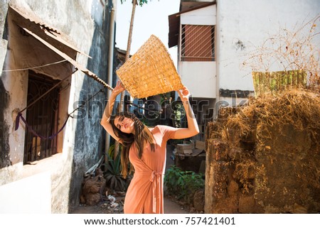 beautiful girl model, in a dress holding a straw basket