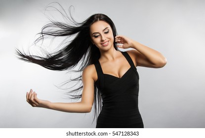 Beautiful Girl Model With Flying The Wind Hair. A Brunette Woman In A Black Dress