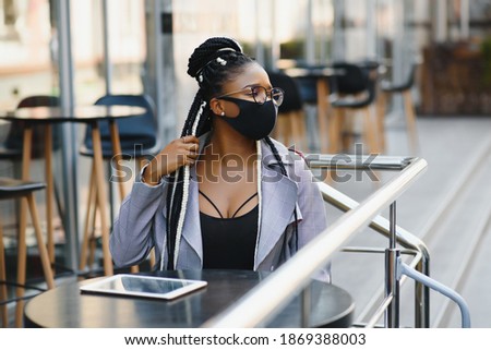 Beautiful girl model with mask due to the coronavirus pandemic covid 19 on the street.