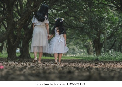 beautiful girl and mother in a park in Hanoi, Vietnam.