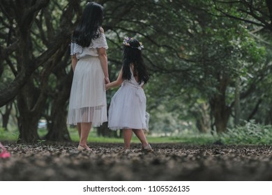 beautiful girl and mother in a park in Hanoi, Vietnam.