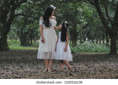 beautiful girl and mother in a park in Hanoi, Vietnam.