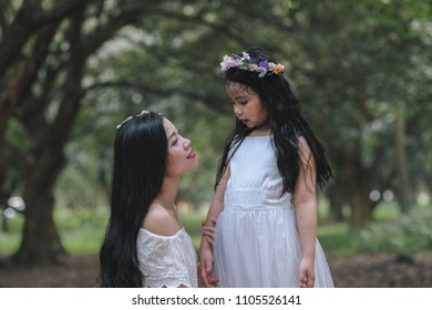 beautiful girl and mother in a park in Hanoi, Vietnam.