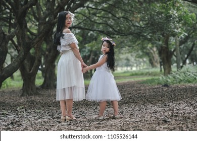 beautiful girl and mother in a park in Hanoi, Vietnam.