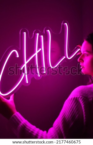 Beautiful girl with neon signs. Pink neon sign chill. Trendy style.  Neon sign. Custom neon. Home decor.
