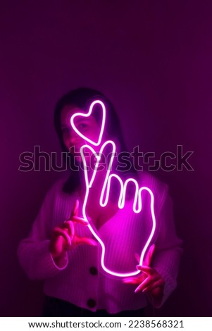 Beautiful girl with neon signs. Pink neon sign love and like. Trendy style. 
 Neon sign. Custom neon. Home decor.