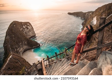 Beautiful girl on the background of Kelingking beach, Nusa Penida Indonesia. A young woman is traveling in Indonesia. Nusa Penida is one of the most famous tourist attraction place to visit in Bali