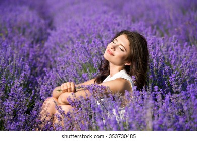Beautiful girl on the lavender field. Beautiful woman in the lavender field on sunset. Soft focus