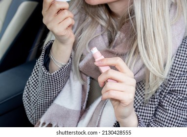 Beautiful Girl Is Painting Her Lips Sitting In A Car And Looking In The Car Vanity Mirror. Blonde Hair Color. Woman Driver.  Sun Visor Mirror Clip On. Beauty And Driving Car Concept.