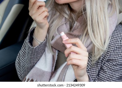 Beautiful Girl Is Painting Her Lips Sitting In A Car And Looking In The Car Vanity Mirror. Blonde Hair Color. Woman Driver.  Sun Visor Mirror Clip On. Beauty And Driving Car Concept.