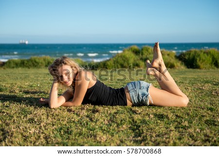 Young, long-legged woman sitting on the Baltic Sea beach