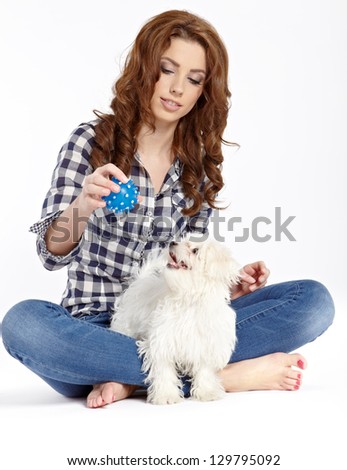 beautiful girl with perfect skin and long wavy hair with a fluffy white dog on a white background