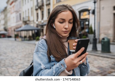beautiful girl with a phone in her hands among the street. Smartphone in hands.
