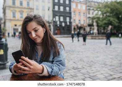 beautiful girl with a phone in her hands among the street. Smartphone in hands.
