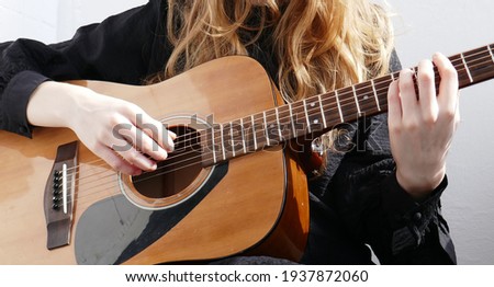 Beautiful girl plays the acoustic guitar. Guitarist on a white background.