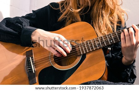 Beautiful girl plays the acoustic guitar. Guitarist on a white background.