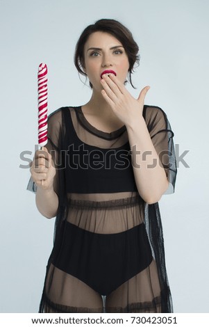 beautiful girl posing with a lollipop in the studio