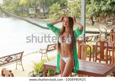 beautiful girl posing in white bikini on tropical resort