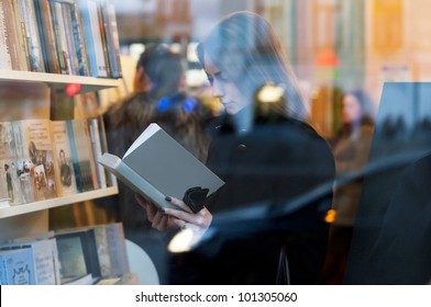 Beautiful Girl Reading A Book In A Bookstore