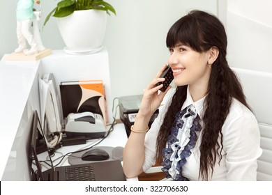 Beautiful Girl At The Reception Desk Answering The Call In Dental Office