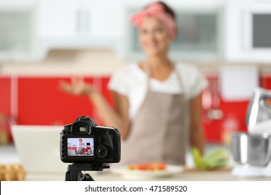 Beautiful girl recording video on camera at kitchen. Food blogger concept - Powered by Shutterstock